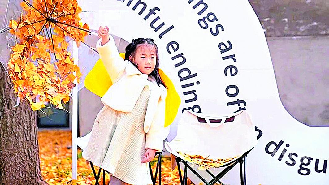 小朋友以銀杏葉為背景拍照留念。 通訊員 趙瑩 攝